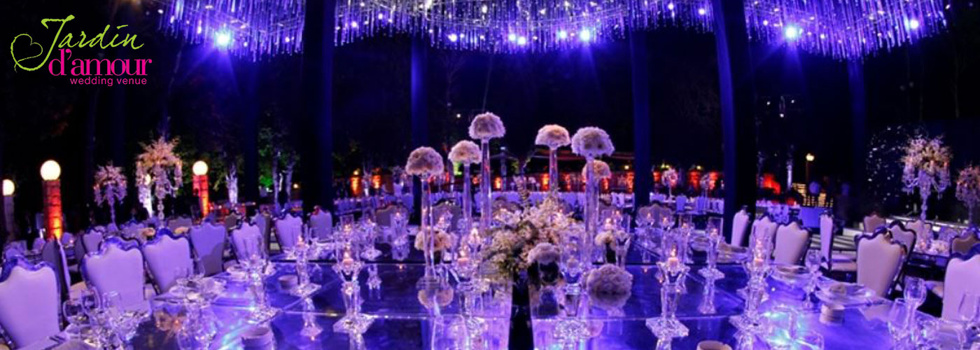 Garden aisle with floral arches and evening lighting